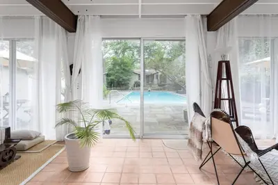 a living room with a large window and a pool at Midcentury Modern ZenHouse Sculptor Studio in Stamford