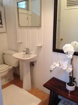 a bathroom with a sink and a toilet and a mirror at Midcentury Modern ZenHouse Sculptor Studio in Stamford