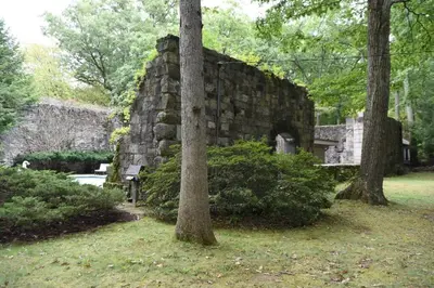 an old stone building in a park with trees at Midcentury Modern ZenHouse Sculptor Studio in Stamford