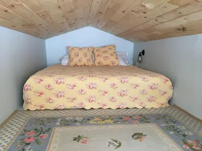 a bedroom with a bed with a yellow comforter at Stratton Chalet in Stratton
