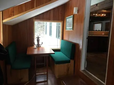 a small room with a table and two green chairs at Stratton Chalet in Stratton