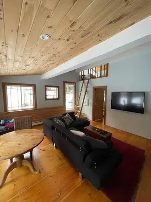 a living room with a black couch and a table at Stratton Chalet in Stratton