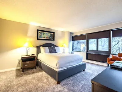 a bedroom with a bed and a desk and windows at Centrally Located Apt Downtown in Stamford