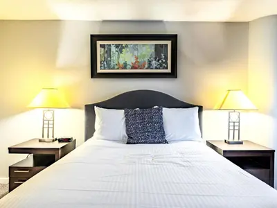 a bedroom with a bed with two lamps on both sides at Centrally Located Apt Downtown in Stamford
