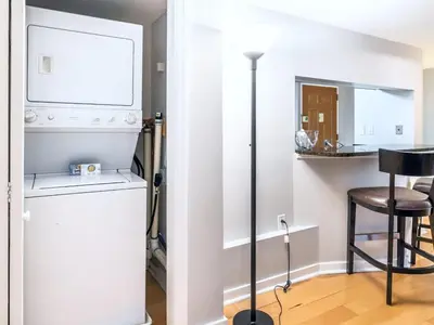 a laundry room with a washer and dryer and a stool at Centrally Located Apt Downtown in Stamford