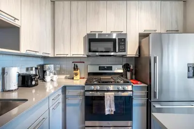 a kitchen with a stainless steel stove and a microwave at Modern Apt with Luxury Amenities in Stamford