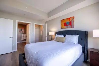 a bedroom with a large bed with white sheets at Modern Apt with Luxury Amenities in Stamford