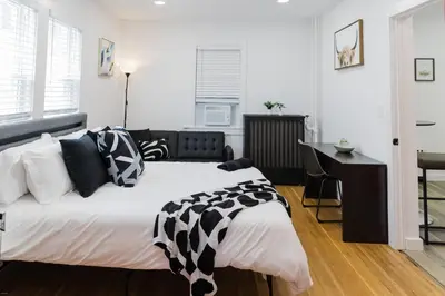 a bedroom with a large bed with black and white pillows at Harty's Terrace 9 Kimball Avenue in Yonkers