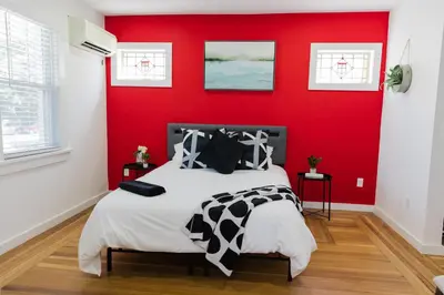 a bedroom with a red wall and a bed at Harty's Terrace 9 Kimball Avenue in Yonkers