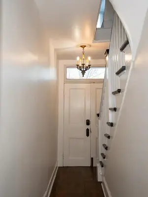 a hallway with a white door and a chandelier at 1BR Hudson Apartment 3Min Walk To Warren St For Two in Hudson