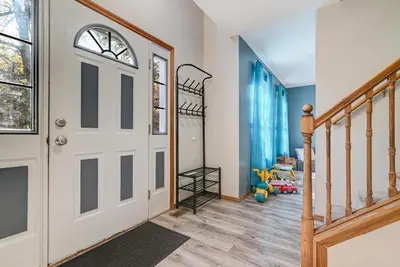 a hallway with a white door and a staircase at Modern Lakefront Oasis Relaxing Hot Tub Sauna Game Rooms Stunning Views! in East Stroudsburg