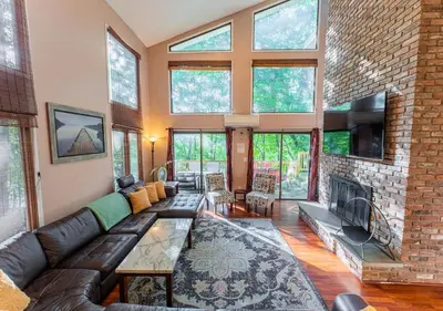a living room with a couch and a fireplace at Charming Lakefront Getaway with Hot Tub & Game Room Perfect for Families! in East Stroudsburg