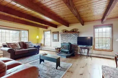 a living room with a couch and a fireplace at Green Mountain Sunrise in Dover