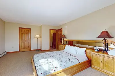 a bedroom with a large bed with a wooden headboard at Green Mountain Sunrise in Dover