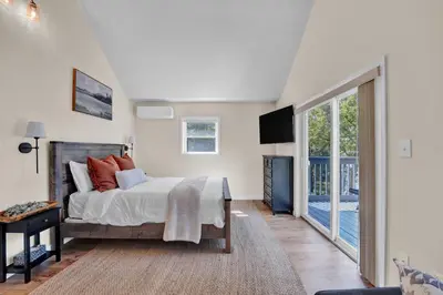 a bedroom with a bed and a sliding glass door at Lakefront, Hot Tub, Dock, Kayaks, Amazing Views in Lake Ariel