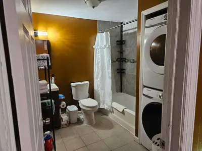 a bathroom with a toilet and a washing machine at Large 3 BRM 2 Bath Near EWR NYC in Newark