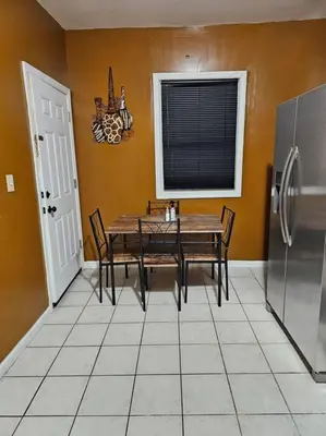 a dining room with a table and a refrigerator at Large 3 BRM 2 Bath Near EWR NYC in Newark