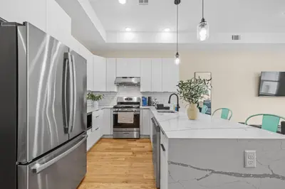 a kitchen with white counters and a stainless steel refrigerator at Skyline Serenity Luxe NYC Retreat in Jersey City