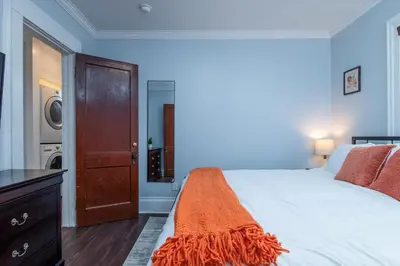 a bedroom with a bed and a washing machine at Fully-stocked Kitchen, AC, WiFi, WD, Near Baseball and Downtown in Oneonta