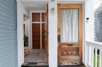 a wooden door leading into a white house at Fully-stocked Kitchen, AC, WiFi, WD, Near Baseball and Downtown in Oneonta