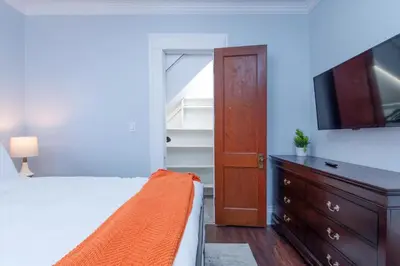 a bedroom with a bed and a tv and a dresser at Fully-stocked Kitchen, AC, WiFi, WD, Near Baseball and Downtown in Oneonta