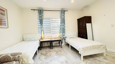 two beds in a room with a window at Fancy private home