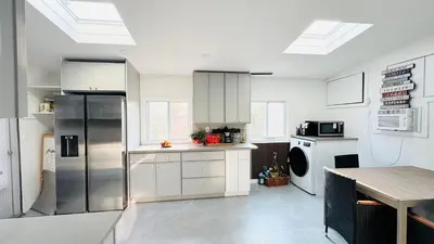 a kitchen with white cabinets and a refrigerator at Fancy private home