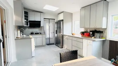 a kitchen with white cabinets and a table and chairs at Fancy private home