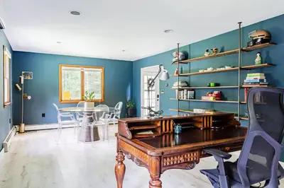 a dining room with blue walls and a wooden table at Eldred Manor in Eldred
