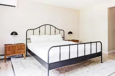 a bedroom with a bed with a metal frame and a table at Eldred Manor in Eldred