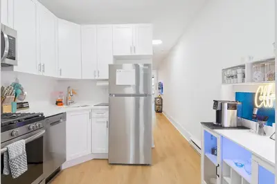 a kitchen with white cabinets and a refrigerator at Hoboken Hideaway - Walk to Transit - 15 Mins to NYC in Hoboken