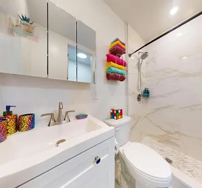 a white bathroom with a toilet and a sink at Hoboken Hideaway - Walk to Transit - 15 Mins to NYC in Hoboken