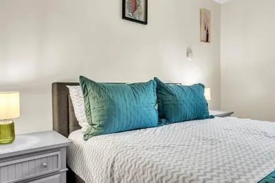 a bedroom with a bed with blue pillows at Crested One Place in Manchester