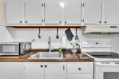 a kitchen with a sink and a microwave at Crested One Place in Manchester
