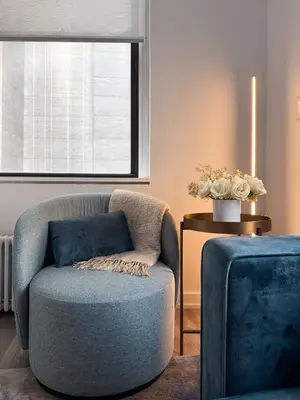 a living room with a blue chair and a window at One Dutch Hotel in New York