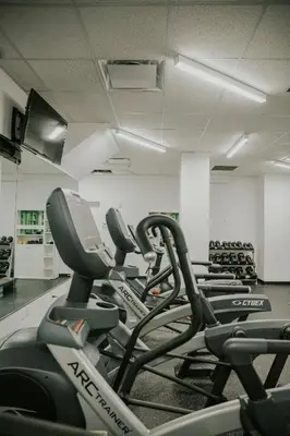 a gym with rows of cardio equipment in a room at One Dutch Hotel in New York