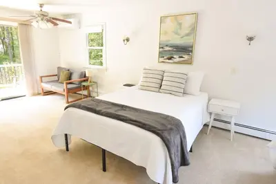 a white bedroom with a bed and a chair at Hudson Valley Haven - NY in Red Hook