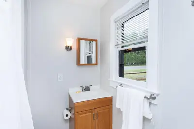 a white bathroom with a sink and a window at Saratoga Cabins in Malta