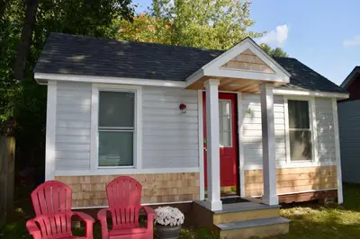 two red chairs in front of a tiny house at Saratoga Cabins in Malta
