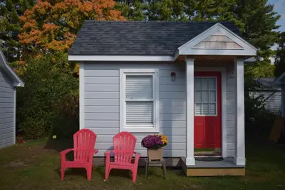 two chairs and a table in front of a tiny house at Saratoga Cabins in Malta