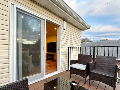 a balcony with two chairs and a sliding glass door at Saugerties Waterfront Getaway in Saugerties