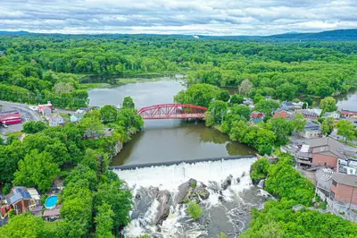 a red bridge over a river with a waterfall at Saugerties Waterfront Getaway in Saugerties