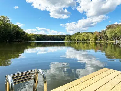 a bench sitting on a dock on a lake at Saugerties Waterfront Getaway in Saugerties