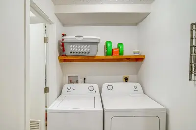 a laundry room with two washing machines and a shelf at Mtn and Foliage Views Modern Mount Snow Stay! in Dover