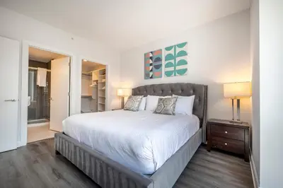 a bedroom with a large bed with white sheets at Luxury Apt Near Downtown in Stamford