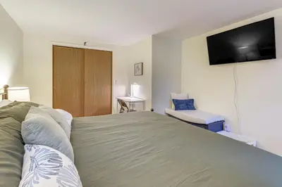 a bedroom with a bed and a flat screen tv at Upstate Winter Escape! 2 Mi to GlobalFoundries in Malta