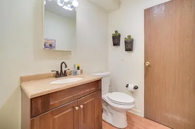 a bathroom with a toilet and a sink and a mirror at Upstate Winter Escape! 2 Mi to GlobalFoundries in Malta
