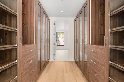 a walk in closet with wooden cabinets at Harlington by Rove Travel Private Backyard & Roof in New York