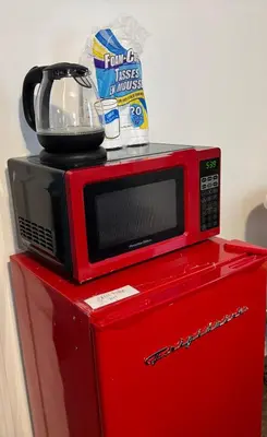 a microwave sitting on top of a red refrigerator at Angelica peaceful place in West Haven