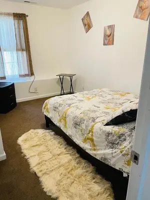 a bedroom with a bed with a rug and a table at Angelica peaceful place in West Haven